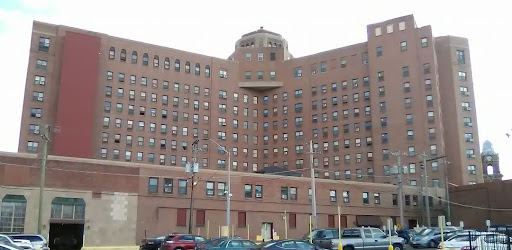 A large brick building with multiple windows, possibly a former hospital or medical facility.