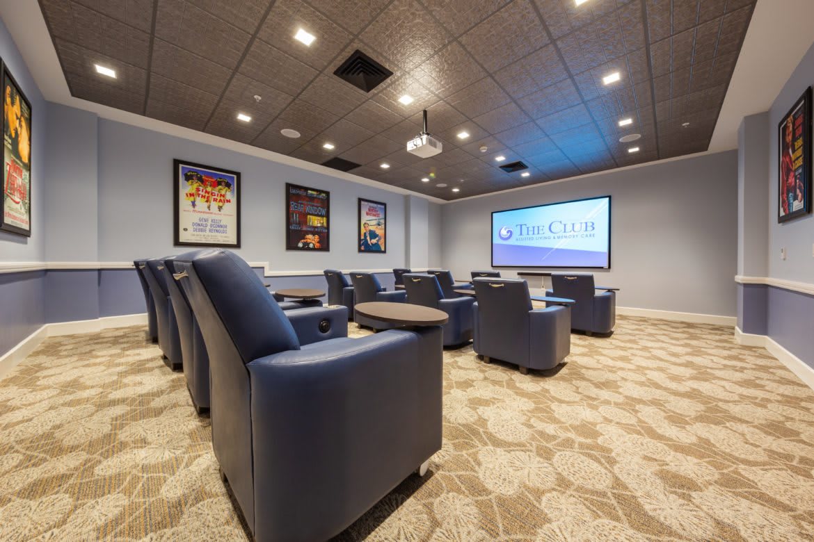 A cozy home theater room with comfortable seating and a large projector screen.