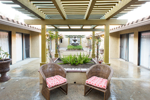 A serene courtyard featuring comfortable seating and lush greenery.
