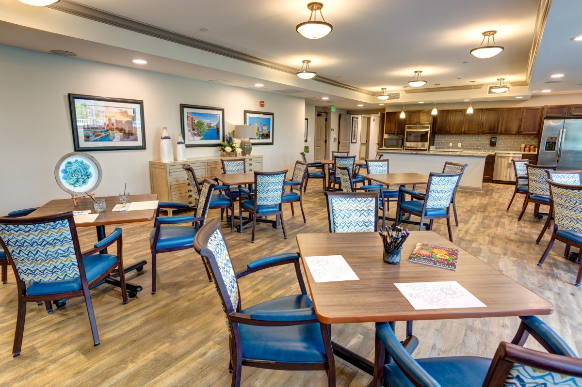 A cozy dining area with neatly arranged tables and chairs, complemented by warm lighting and elegant decor.