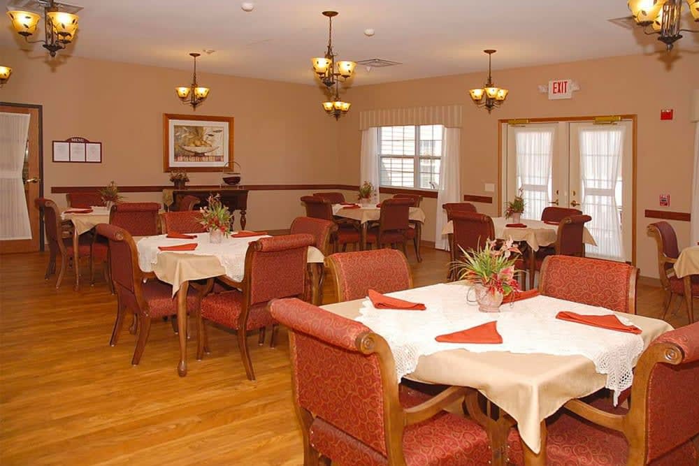 An elegantly decorated dining room with multiple tables set for guests.