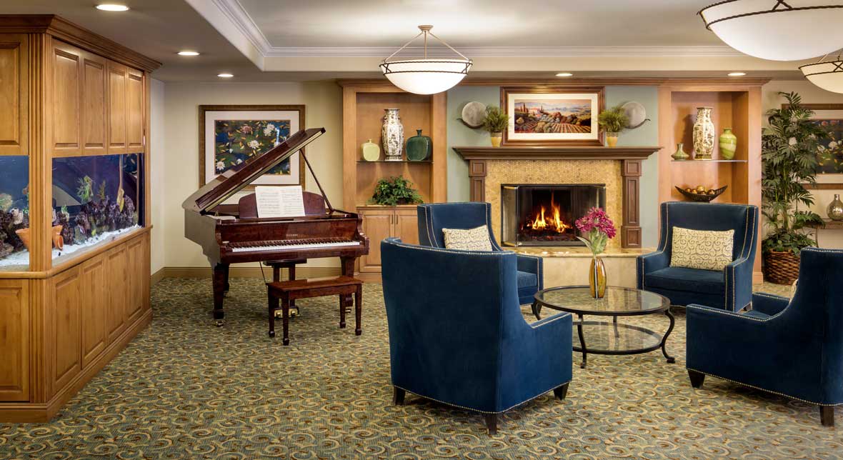 A cozy living room with a grand piano, fireplace, and comfortable seating.
