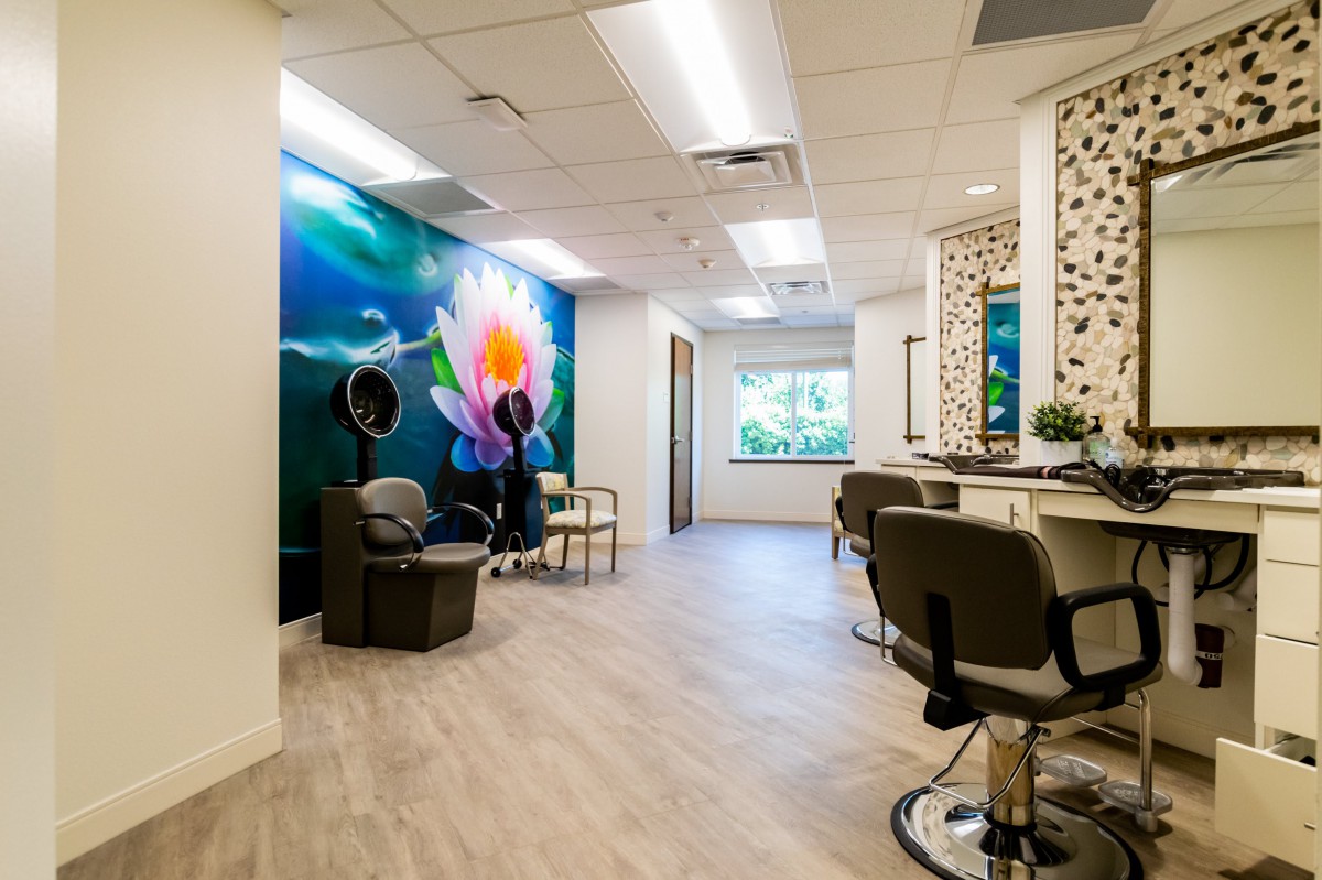 A modern hair salon interior with decorative murals and comfortable seating.
