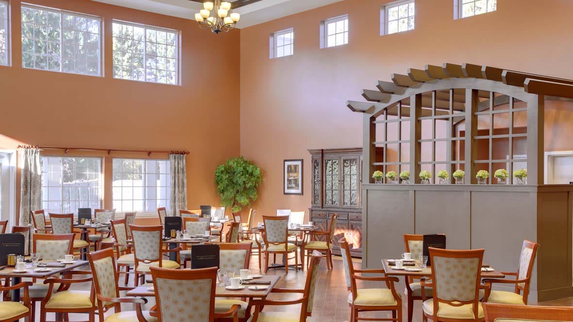 A well-lit dining area with neatly arranged tables and chairs.