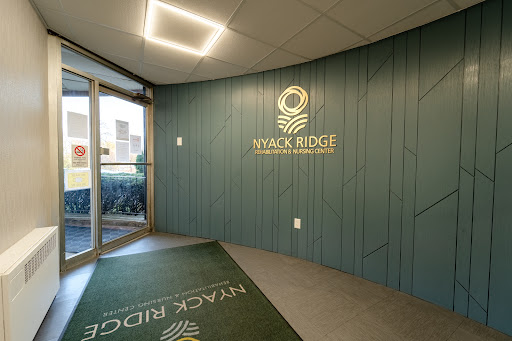 The modern lobby of Wyack Ridge featuring a stylish green accent wall and branded signage.