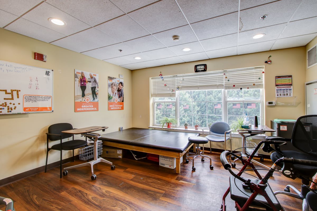 A physical therapy clinic with a treatment table and exercise equipment.