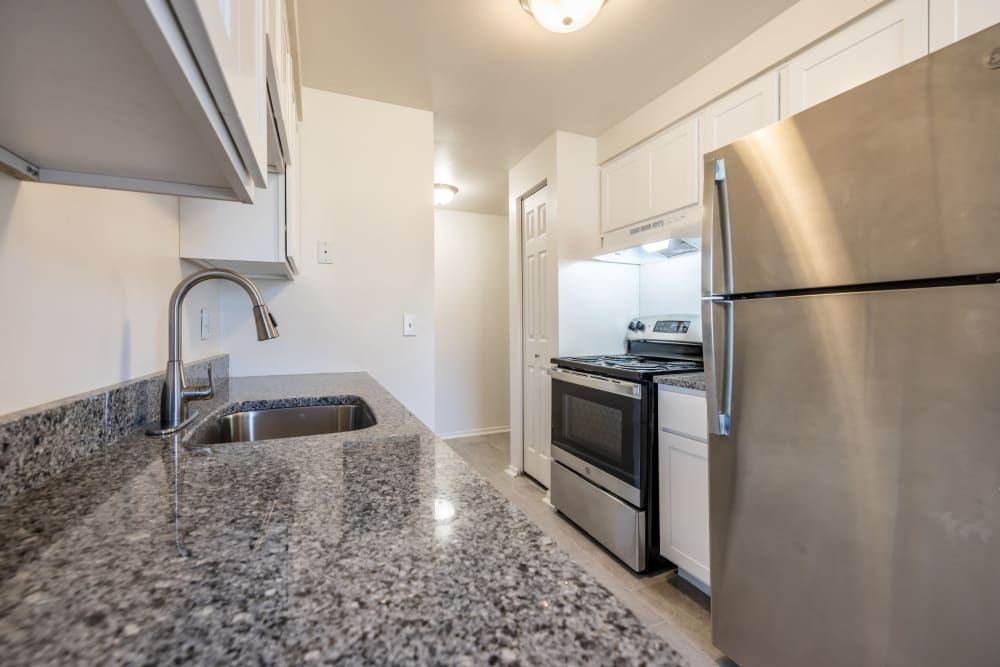 A modern kitchen with granite countertops and stainless steel appliances.
