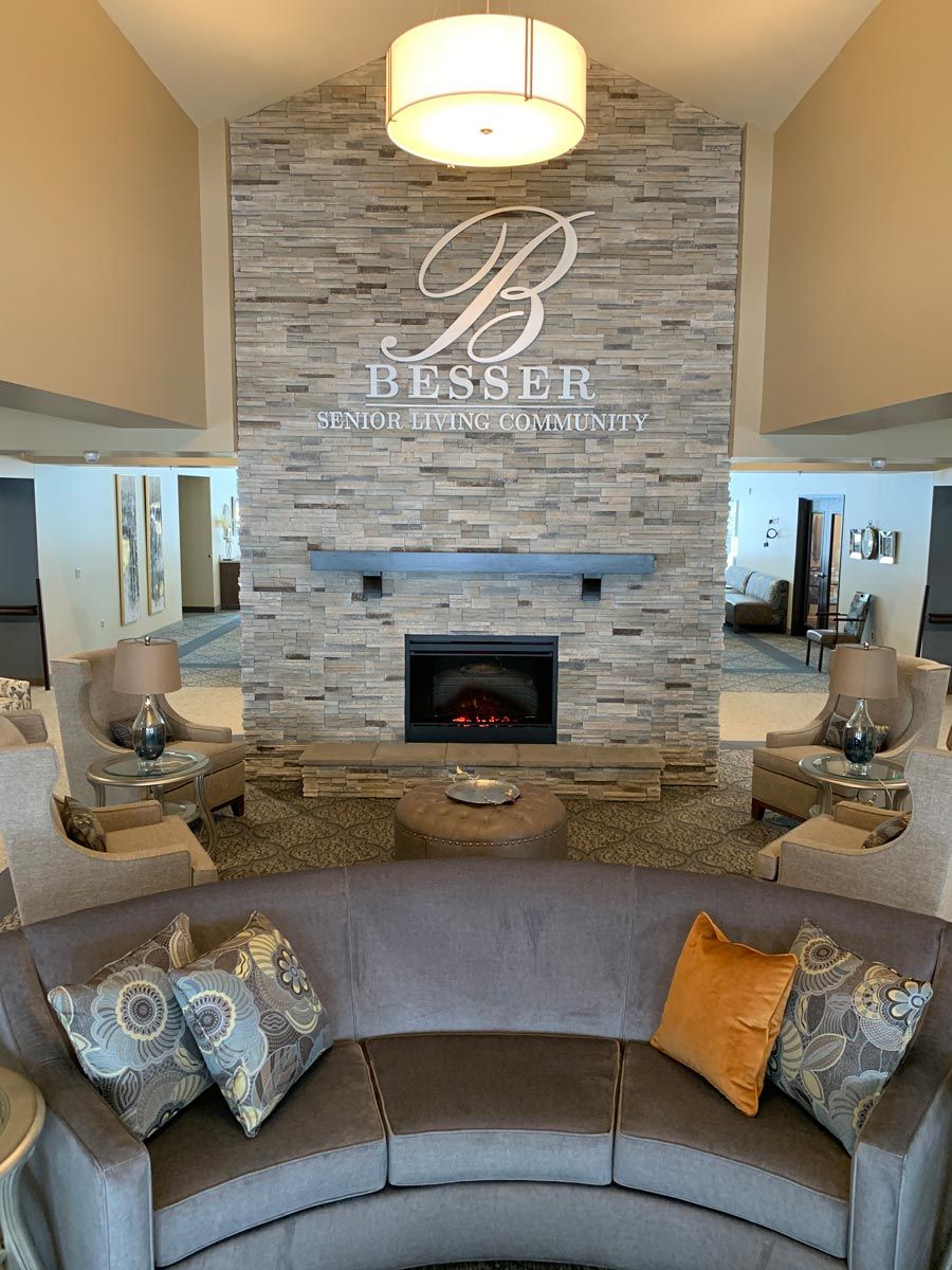 A modern lobby with a central fireplace and comfortable seating.