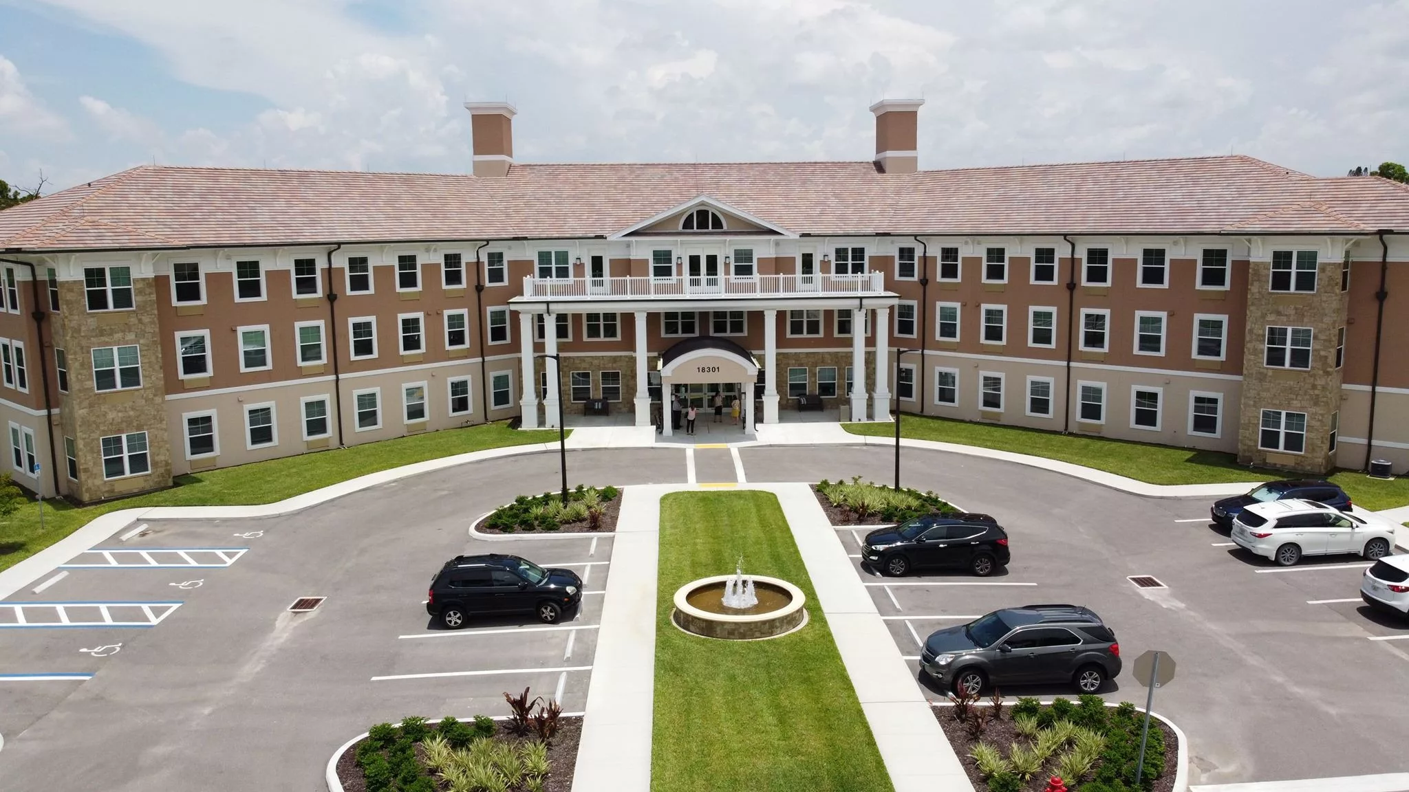 A large building with a grand entrance and surrounding parking lot.