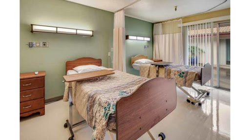 A serene patient room in a hospital, equipped with beds and soft lighting.