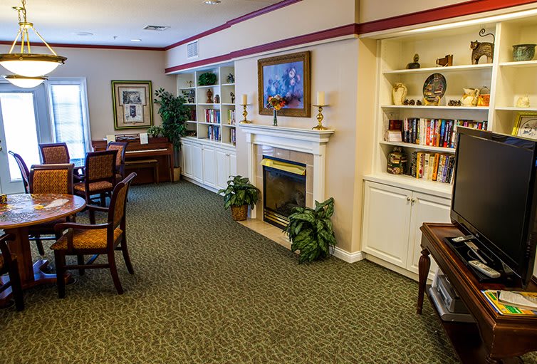 A cozy living room with a fireplace, bookshelves, and elegant decor.