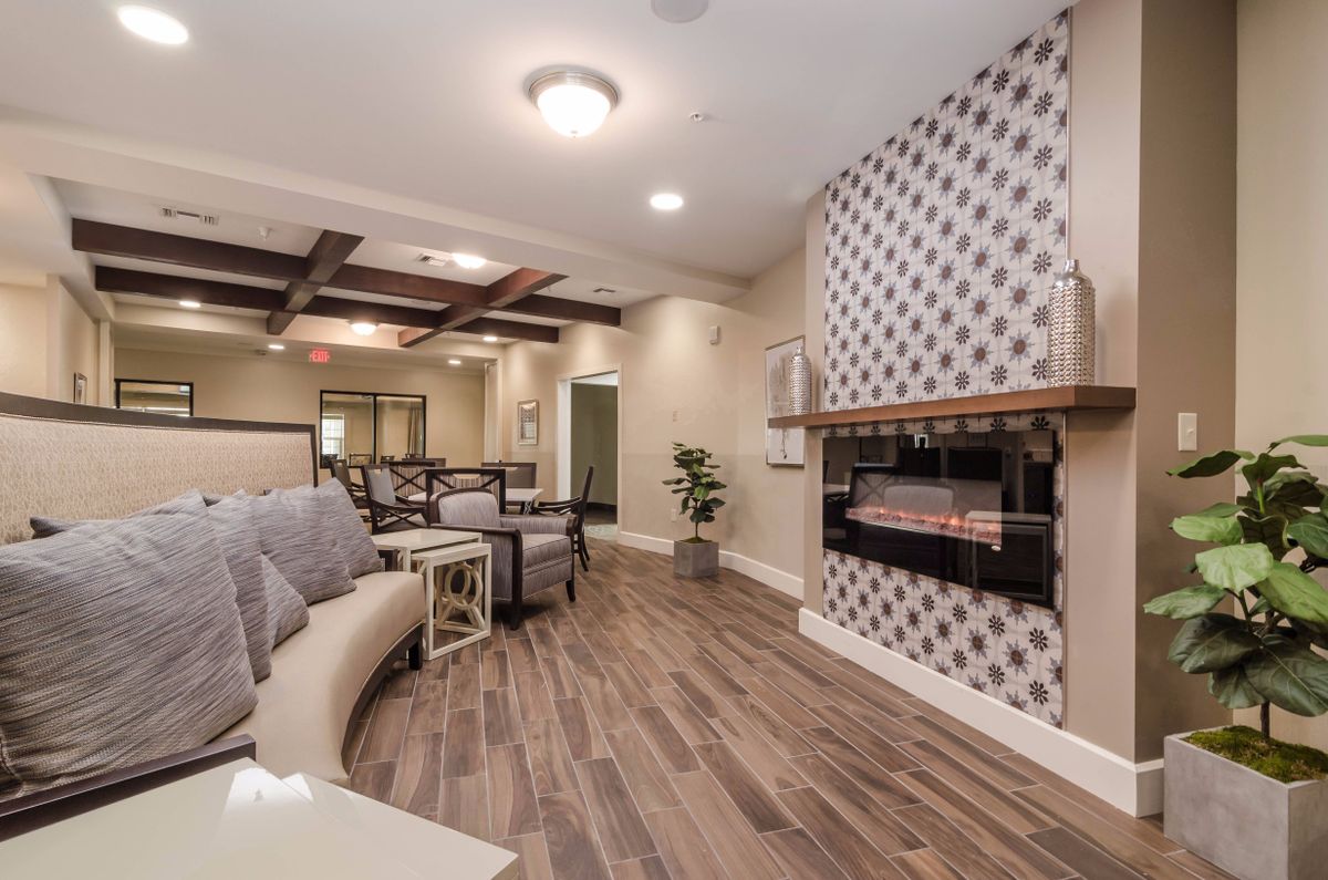 A cozy living room with modern decor featuring a stylish fireplace, comfortable seating, and elegant wood flooring.