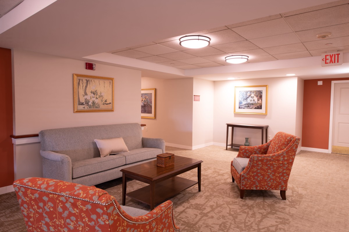 A cozy lounge area with comfortable seating, artwork on the walls, and warm lighting.