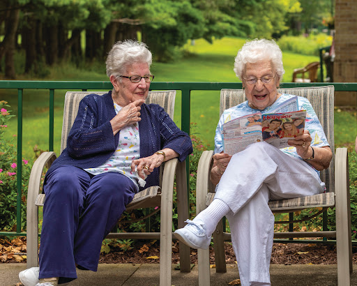 Two elderly women enjoying a peaceful moment together in nature, sharing laughter and stories.