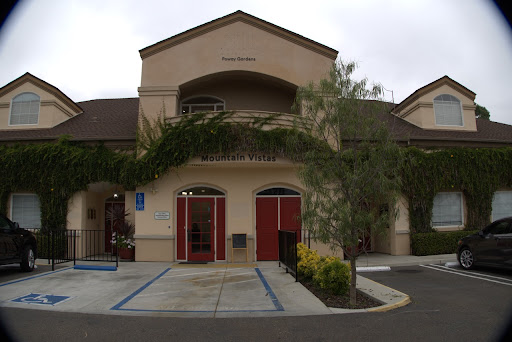 A view of a charming two-story building with inviting entrances and lush landscaping.