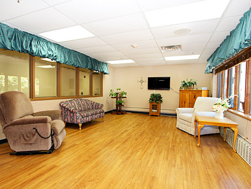 A spacious and well-lit living area featuring comfortable sofas, a television, and decorative plants.