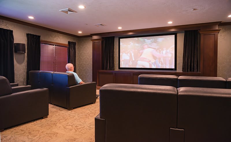 A cozy home theater with comfortable seating and a large projection screen.
