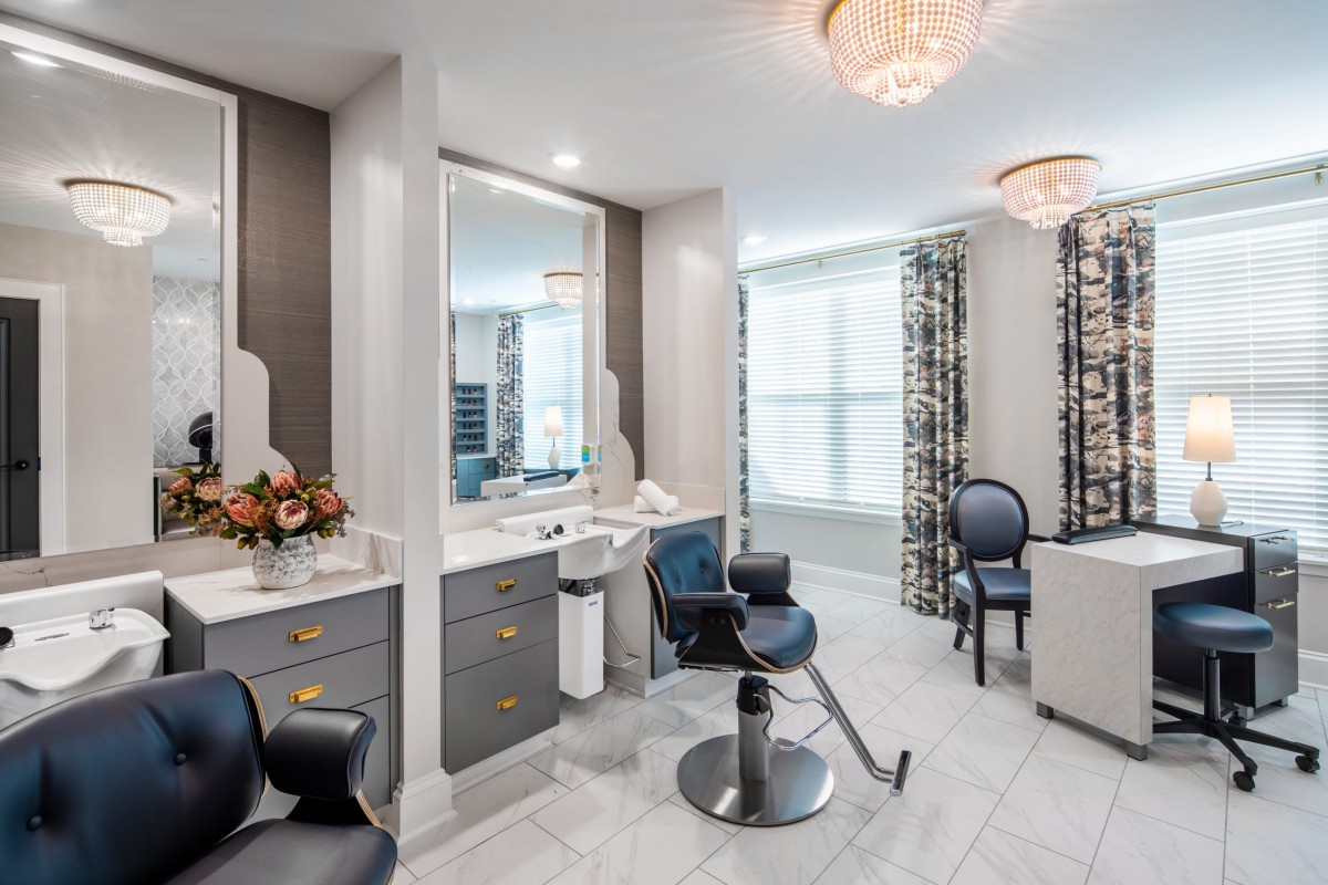 A modern hair salon interior with stylish chairs, mirrors, and elegant lighting.