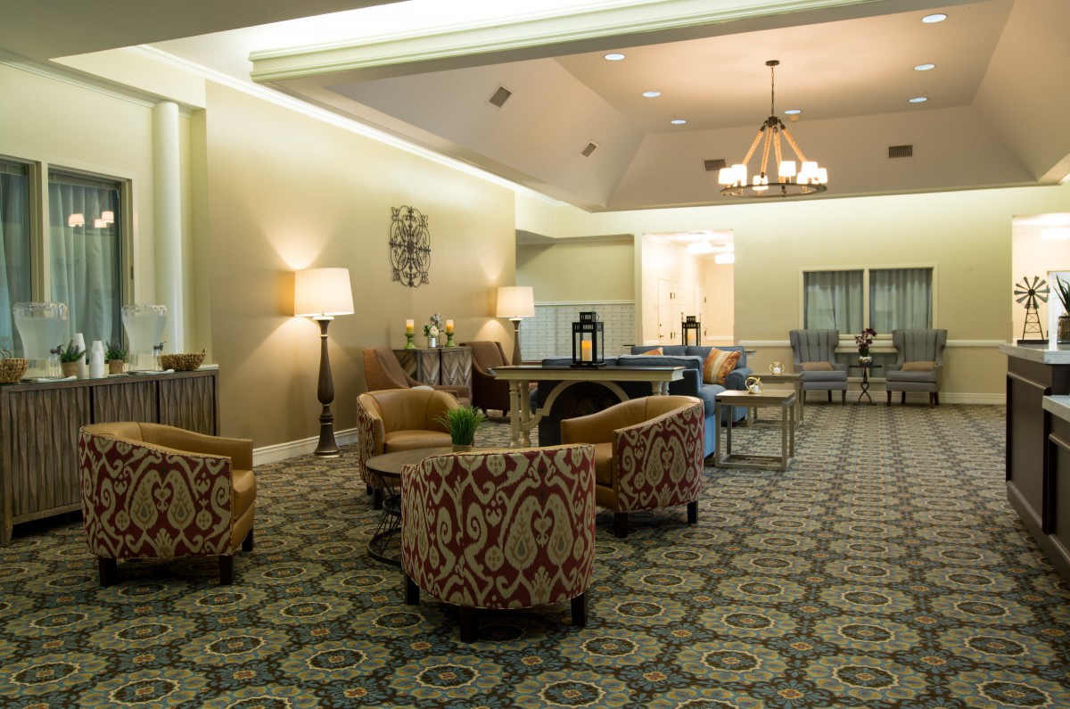 A cozy lobby with patterned chairs, elegant lighting, and a spacious seating arrangement.
