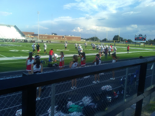A lively scene at a football game with cheerleaders supporting their team on the sidelines.