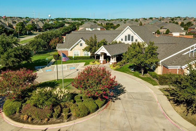 Aerial view of a suburban house with a landscaped driveway.