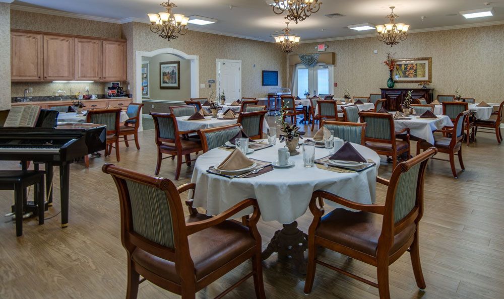 An elegantly furnished dining room with neatly arranged tables and chandeliers.