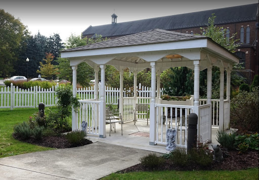 A charming white gazebo surrounded by lush greenery, perfect for outdoor gatherings and relaxation.
