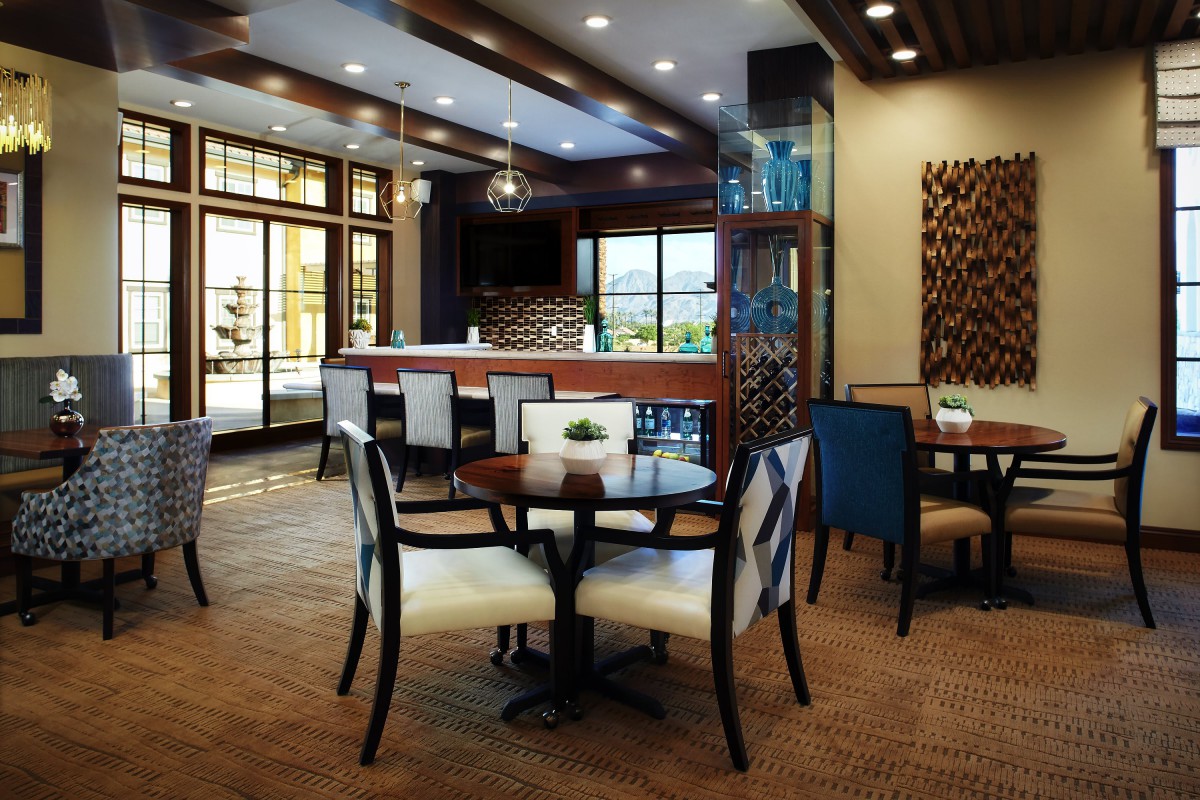 A modern restaurant dining area with stylish tables and chairs, featuring large windows and elegant interior design.