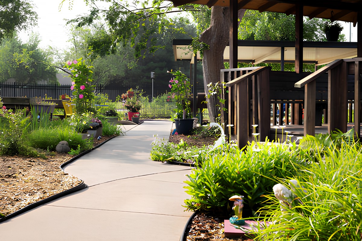 A beautifully landscaped garden with a winding pathway surrounded by lush plants.