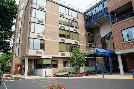 A modern multi-story building featuring large windows and an inviting entrance.