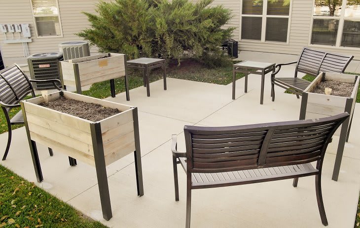 A cozy outdoor patio area with tables, chairs, and planter boxes.