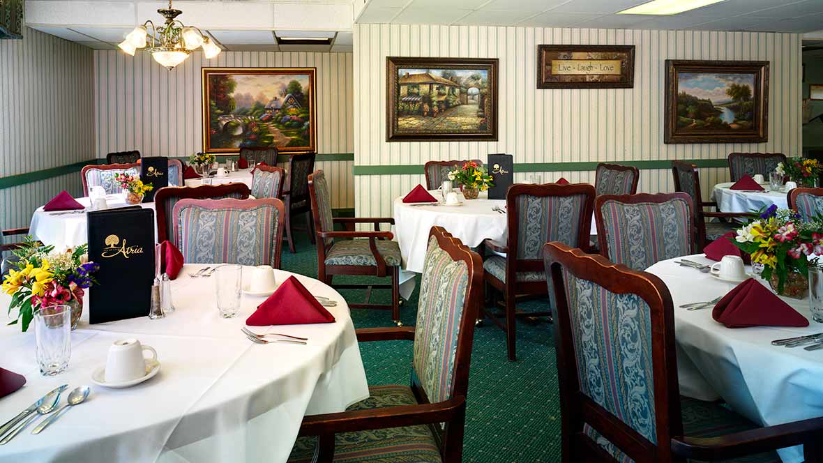 An elegantly decorated restaurant dining room with neatly arranged tables and chairs.