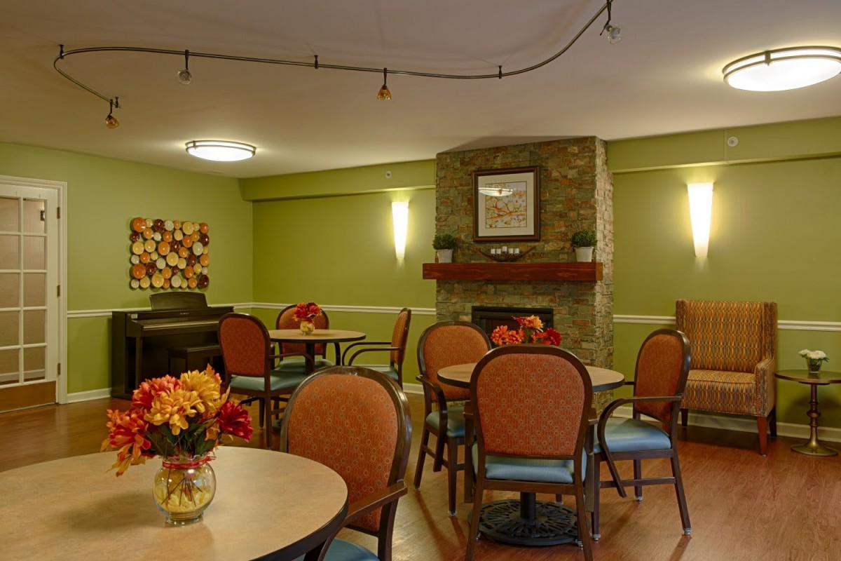 Cozy dining area with tables, chairs, and a fireplace.