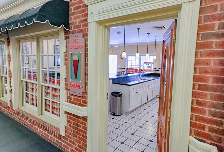Interior view of an ice cream parlor kitchen with a counter and tiled floor.