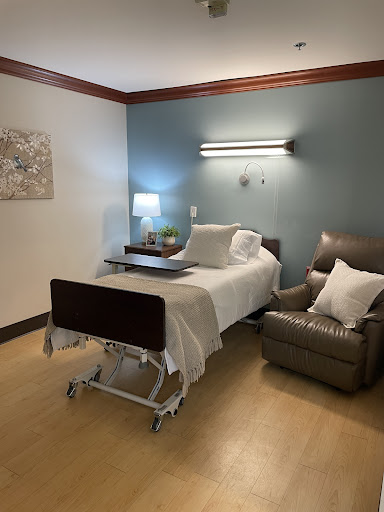 A well-equipped hospital room with a patient bed, a comfortable chair, and soothing decor.