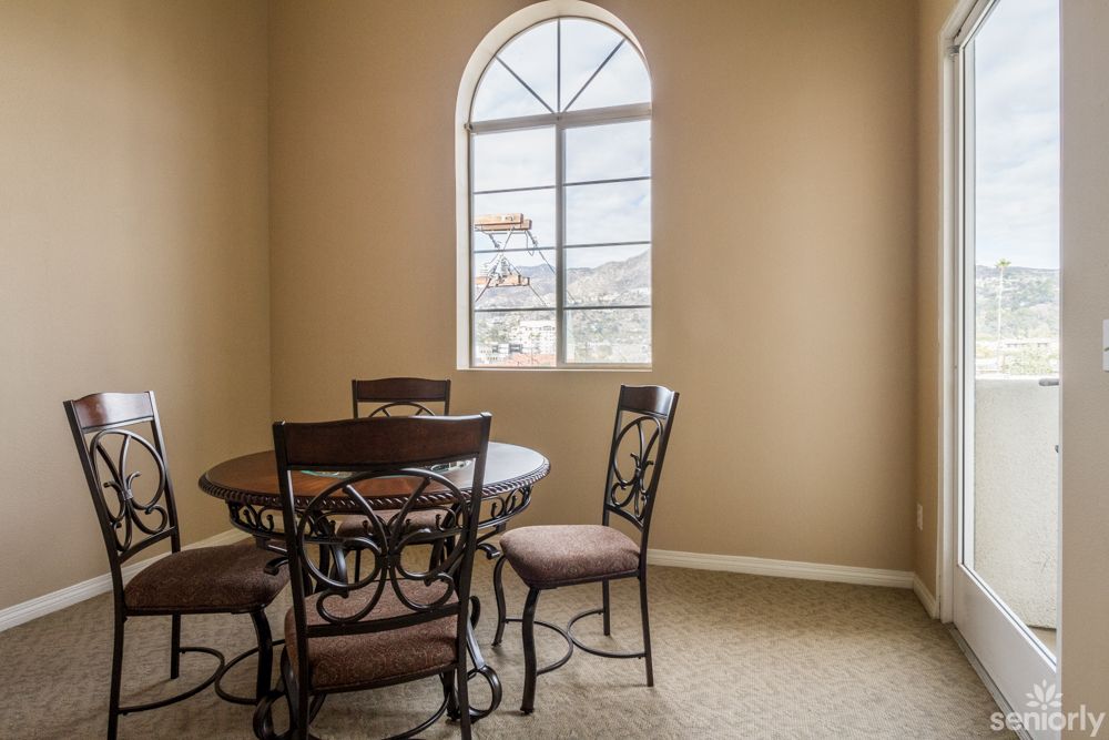 A cozy dining area with an arched window and a round table.