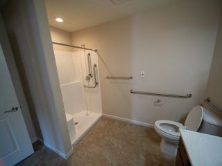 An accessible bathroom with a walk-in shower and handrails.
