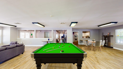 A vibrant pool table set in a spacious game room, perfect for recreation and social gatherings.