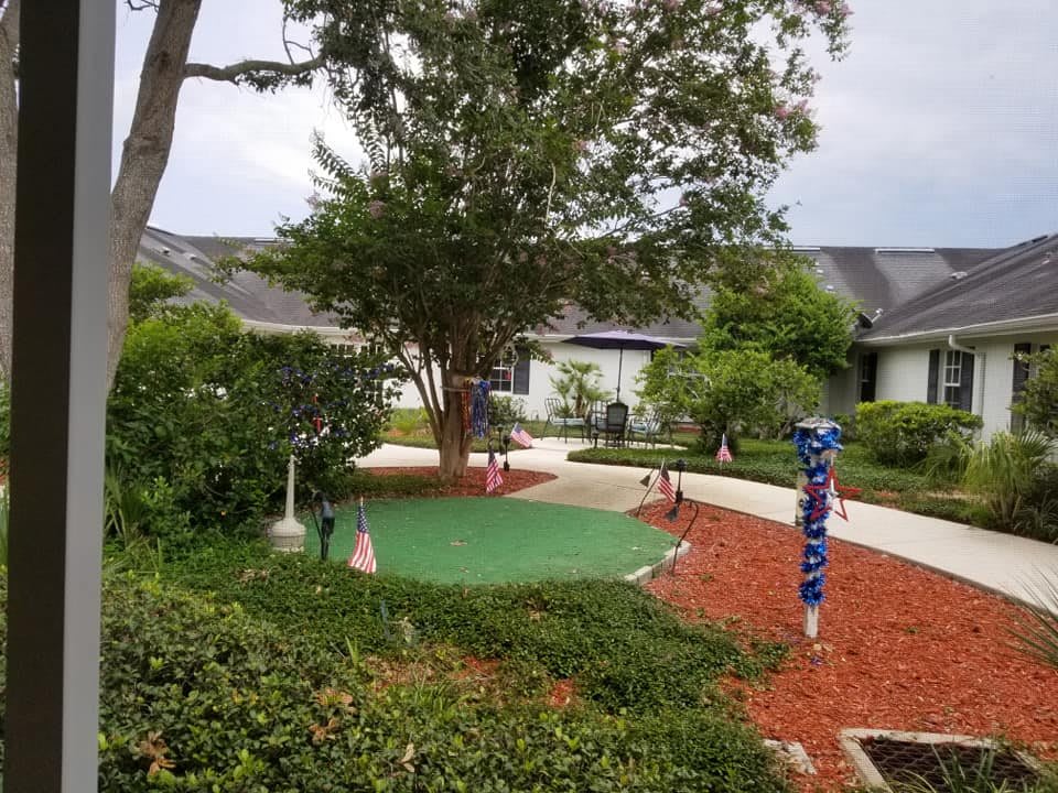 A scenic garden area featuring a mini golf course with surrounding pathways and trees.