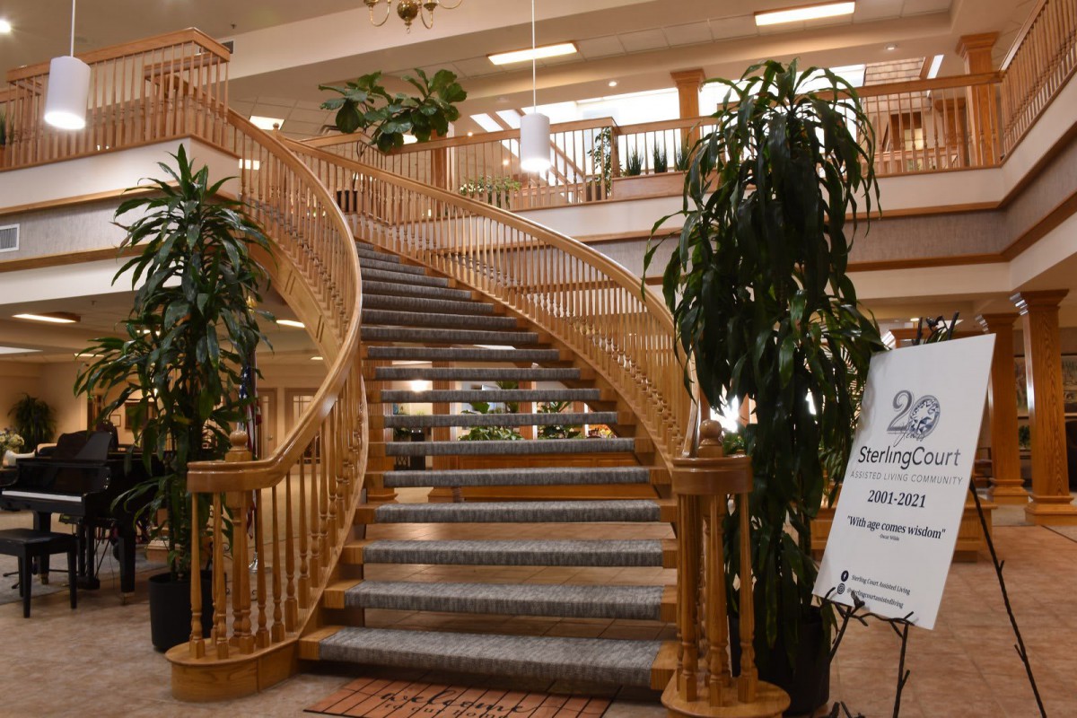 Elegant wooden staircase with plants in a spacious interior.
