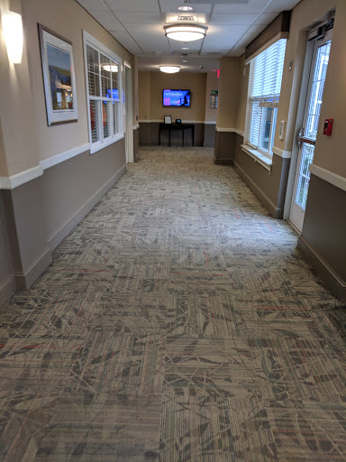 A well-lit indoor hallway with patterned carpet and access to other rooms.
