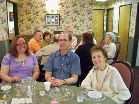 A group of people sitting at a table during a social gathering.