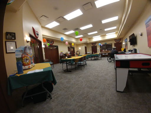 A spacious recreational room set up with tables and colorful decorations, ready for an event.