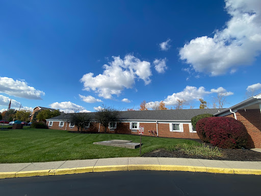 A charming residential building set against a bright blue sky with fluffy clouds.