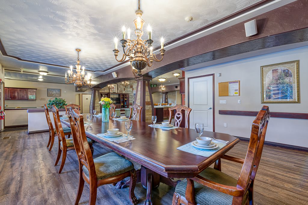 Elegant dining room with a set table and chandeliers.