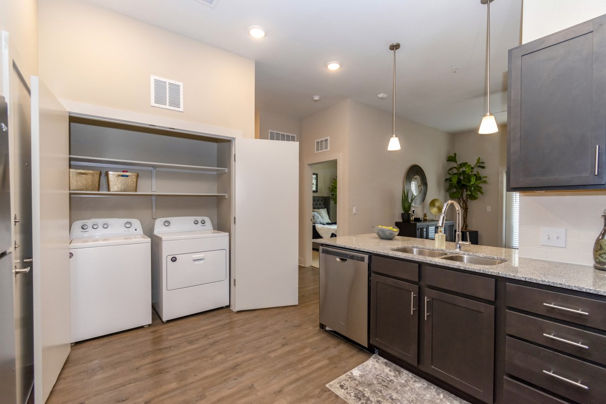 Modern kitchen with integrated laundry area featuring a washing machine and dryer.