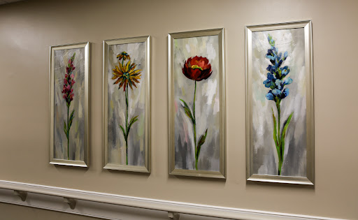 A series of vibrant floral paintings elegantly framed on a wall, enhancing the interior decor.