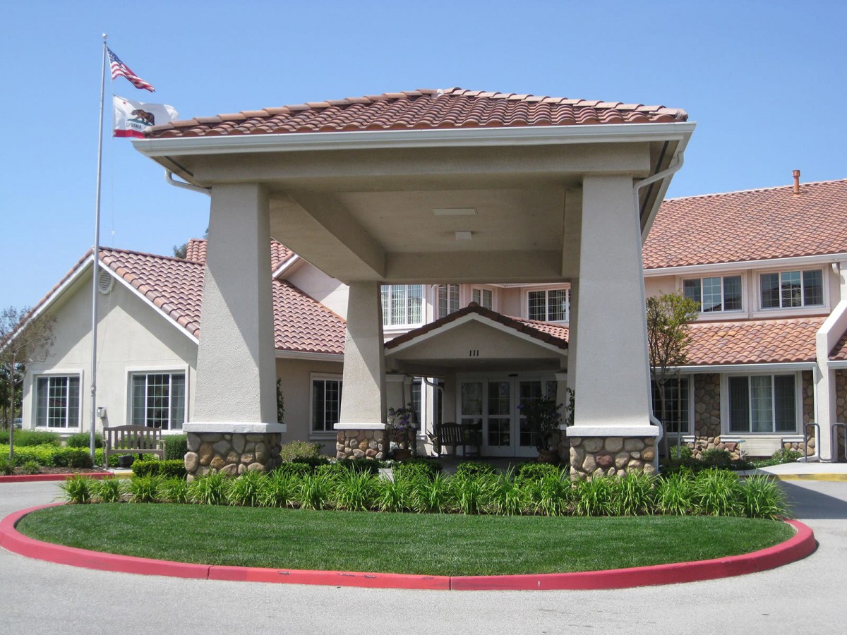 A residential building with a covered entrance and well-maintained landscaping.