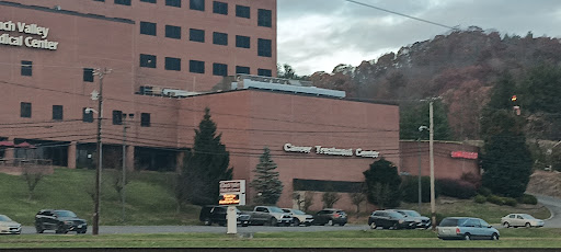 A view of a medical facility, showcasing its brick architecture and surrounding landscape.