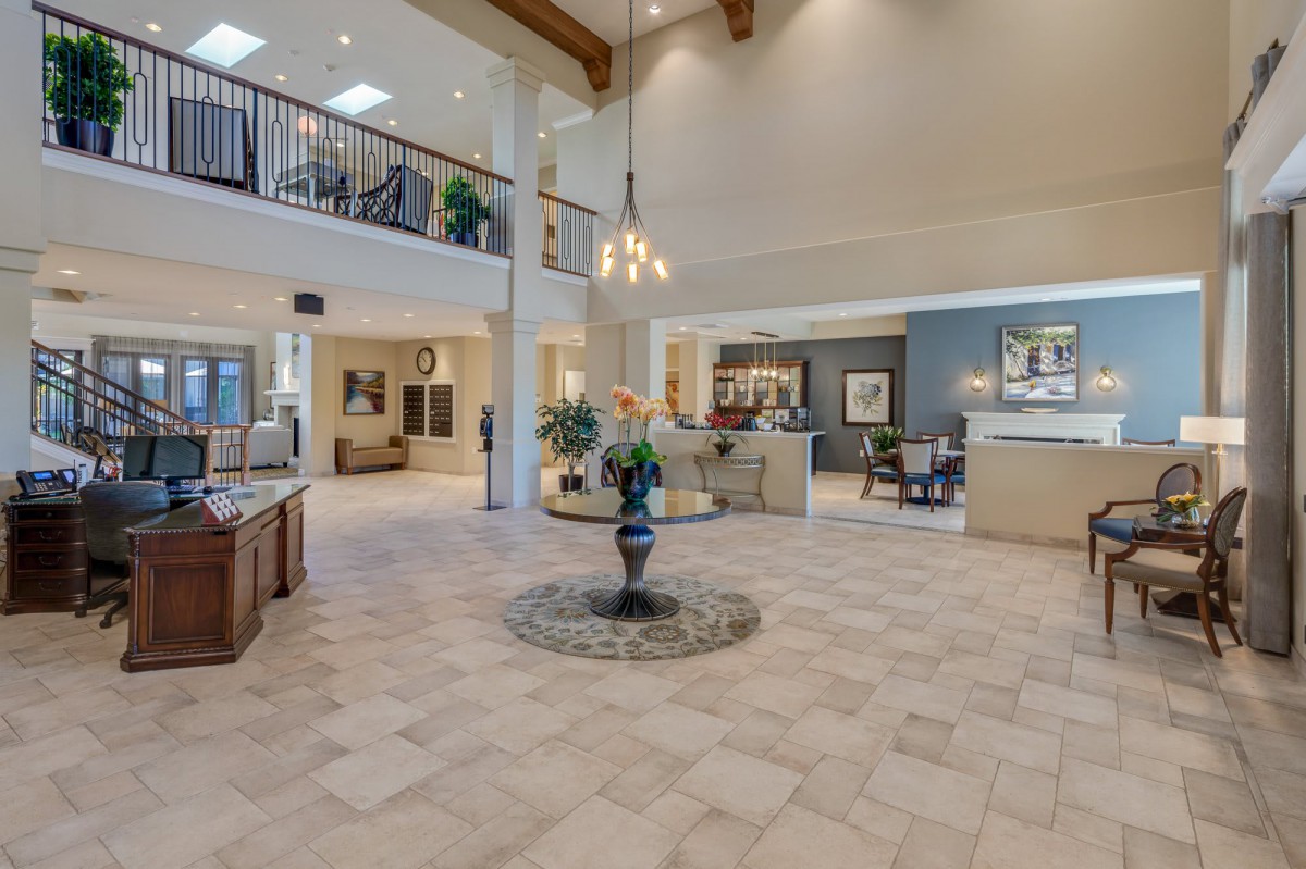 A spacious and elegantly decorated lobby area with modern furnishings and a central table feature.
